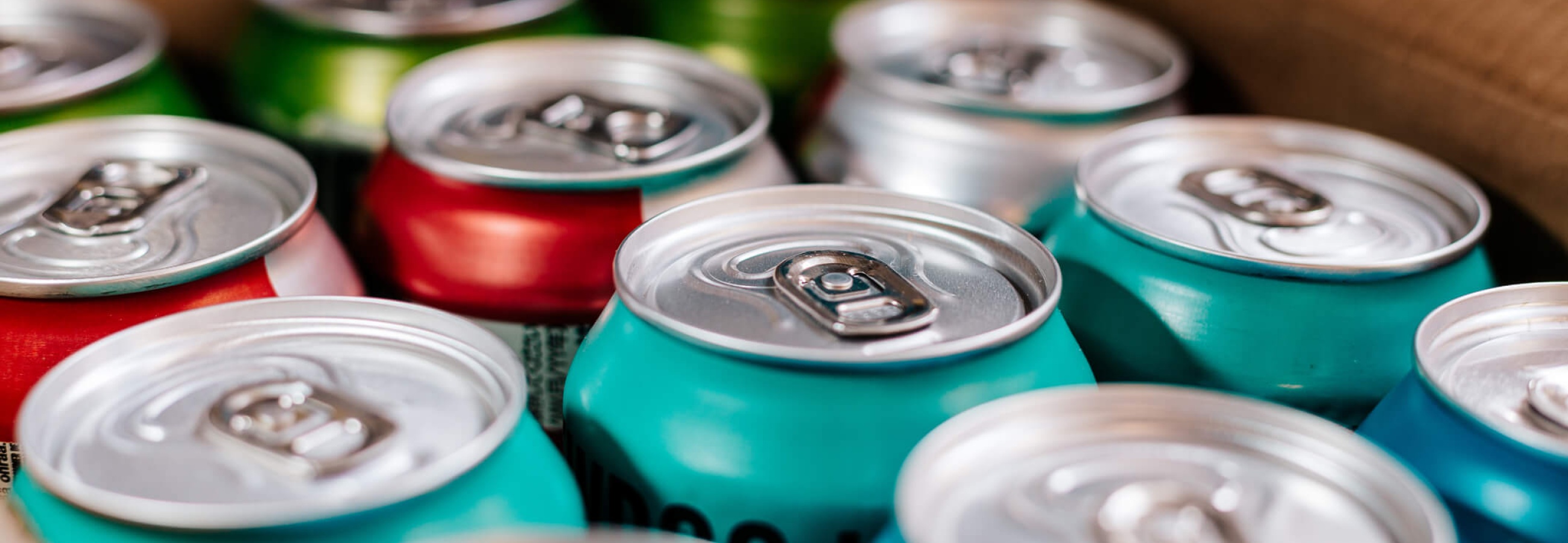 A close-up of assorted soda cans in a cardboard box