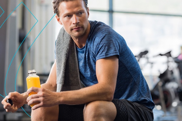 Person at the gym drinking a performance beverage.